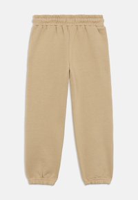 Μπεζ φόρμες από μαλακό ύφασμα, με ελαστική μέση και εφαρμοστά τελειώματα στους αστραγάλους. Απλός, κανονικός σχεδιασμός με ίσια γραμμή στο πόδι.