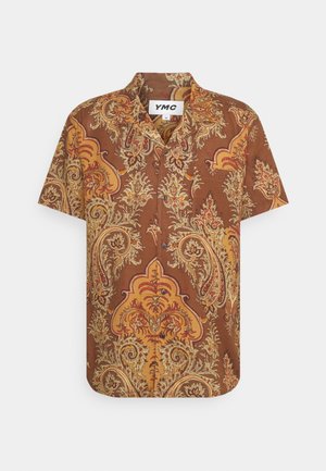 Camicia a maniche corte con bottoni, fantasia paisley marrone e gialla, colletto aperto e etichetta del marchio YMC all'interno della scollatura.