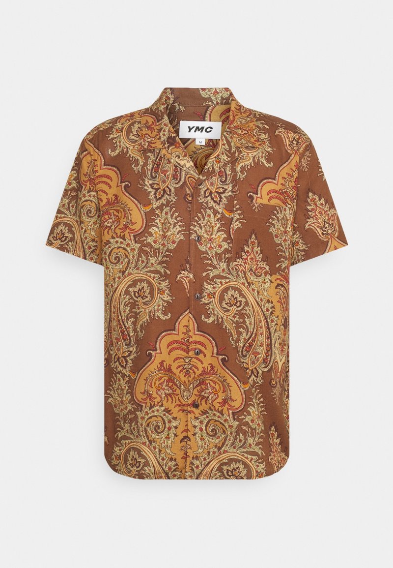 Chemise à manches courtes avec boutons, motif cachemire marron et jaune, col large et étiquette de la marque YMC à l’intérieur de l’encolure.