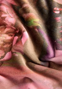 Tkanina o miękkiej, pluszowej fakturze, łącząca odcienie różu, brązu i zieleni, przedstawiająca kwiatowy wzór z gładkimi krzywiznami i fałdami.