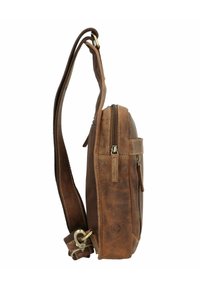 Borsa a tracolla in pelle marrone con scomparto principale con zip, tasca laterale, tracolla regolabile e dettagli in ottone. Texture liscia.