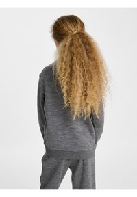 Grå texturerad sweatshirt och matchande byxor, med långt, lockigt hår på baksidan; avslappnad passform med ribbamanschetter och midja.