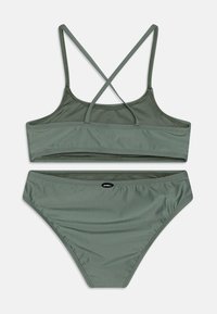 Grønn to-delt bikini med justerbare kryssede stropper på toppen og høyhælte bunn. Glatt tekstur og logo aksent på midjebeltet.