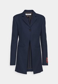 Námořnický blazer z vlněné směsi s jedním knoflíkem, klopami, dvěma předními kapsami a barevným nápletem na levém rukávu.