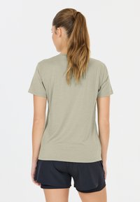 Khaki t-shirt van zachte stof, met korte mouwen en een ronde halslijn, gecombineerd met zwarte sportshorts.
