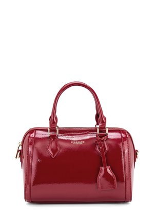 Red patent leather handbag with rounded shape, double top handles, and a detachable tag. Features gold-tone hardware and zipper closure.
