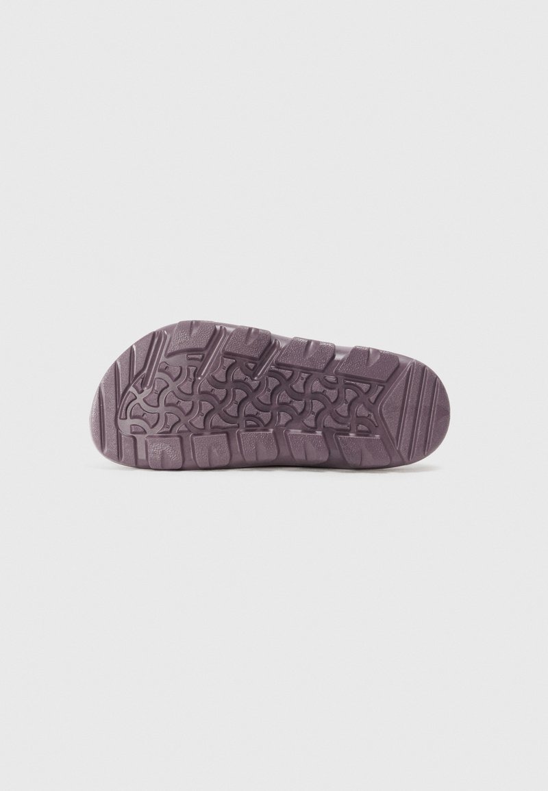 Semelle de chaussure en caoutchouc violet muted, avec un motif de texture pour une meilleure adhérence, comprenant des éléments surélevés pour la traction et la durabilité.
