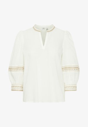 Hvid blouse med V-udskæring og puffærmer. Har dekorativ beige broderi langs ærmekanterne og halsudskæringen. Blødt, let materiale.