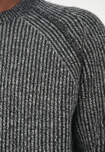 Πλεκτός πούλεντ σε μαύρο και γκρι, με ραμμένο σχέδιο, στρογγυλή λαιμόκοψη και σχεδίαση μανικιών ρακλάν.