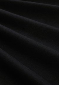Schwarzer Stoff mit glatter Textur, der subtile horizontale Falten aufweist. Das Material scheint leicht zu sein und ist wahrscheinlich Baumwolle oder eine Mischung.