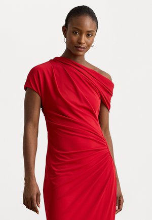 Rochie roșie, ajustată, dintr-un material moale și elastic. Design fără bretele, cu detalii drapate și textură pliuată pe lateral.