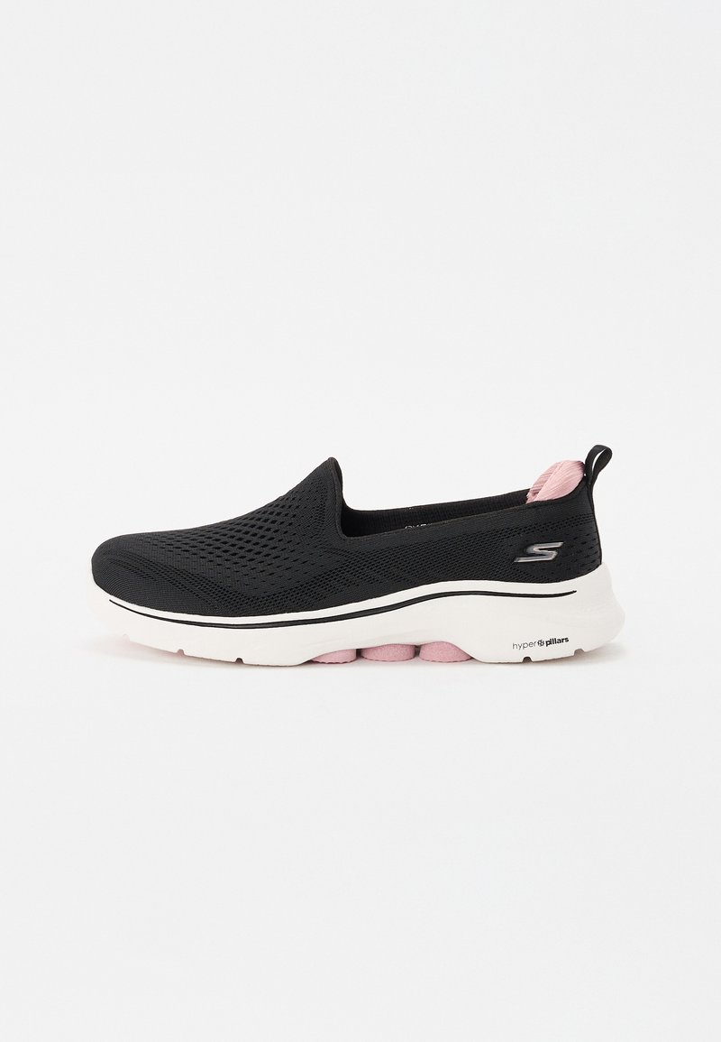 Sapatilha slip-on preta com parte superior em malha, sola intermédia branca com detalhes em rosa, bico arredondado e design texturizado para respirabilidade.