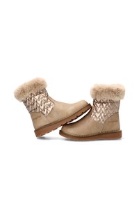 Botas infantiles de invierno color marrón claro con laterales metálicos acolchados, ribete de piel sintética y suelas de goma, colocadas talón con punta sobre fondo blanco.