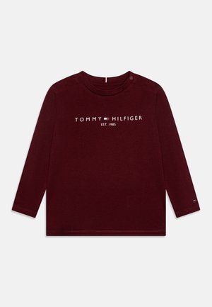 Kindergröße, langärmeliges Shirt in Weinrot mit dem Schriftzug "Tommy Hilfiger EST. 1985" und Logo mittig auf der Brust sowie kleinem Logo am linken Ärmelbündchen.