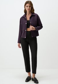 Donkerpaars cropped jack met een puntkraag, knoopsluitingen, twee voorzakken, gecombineerd met zwarte slim-fit broek en zwarte instappers.