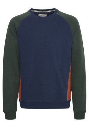 Sininen ja vihreä väriin jaettu collegepaita, jossa on raglan-hihat. Sileä pinta, joustavat hihansuut ja helmassa. Toinen puoli oranssi korostus.