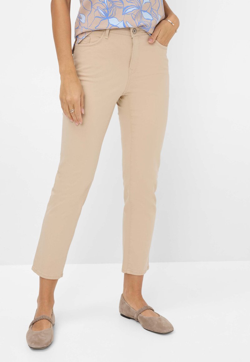 Beige Slim-Fit-Hosen aus Baumwollmischung mit einem klassischen Fünf-Taschen-Design und normaler Bundhöhe, kombiniert mit taupefarbigen Wildleder-Balletschuhen.