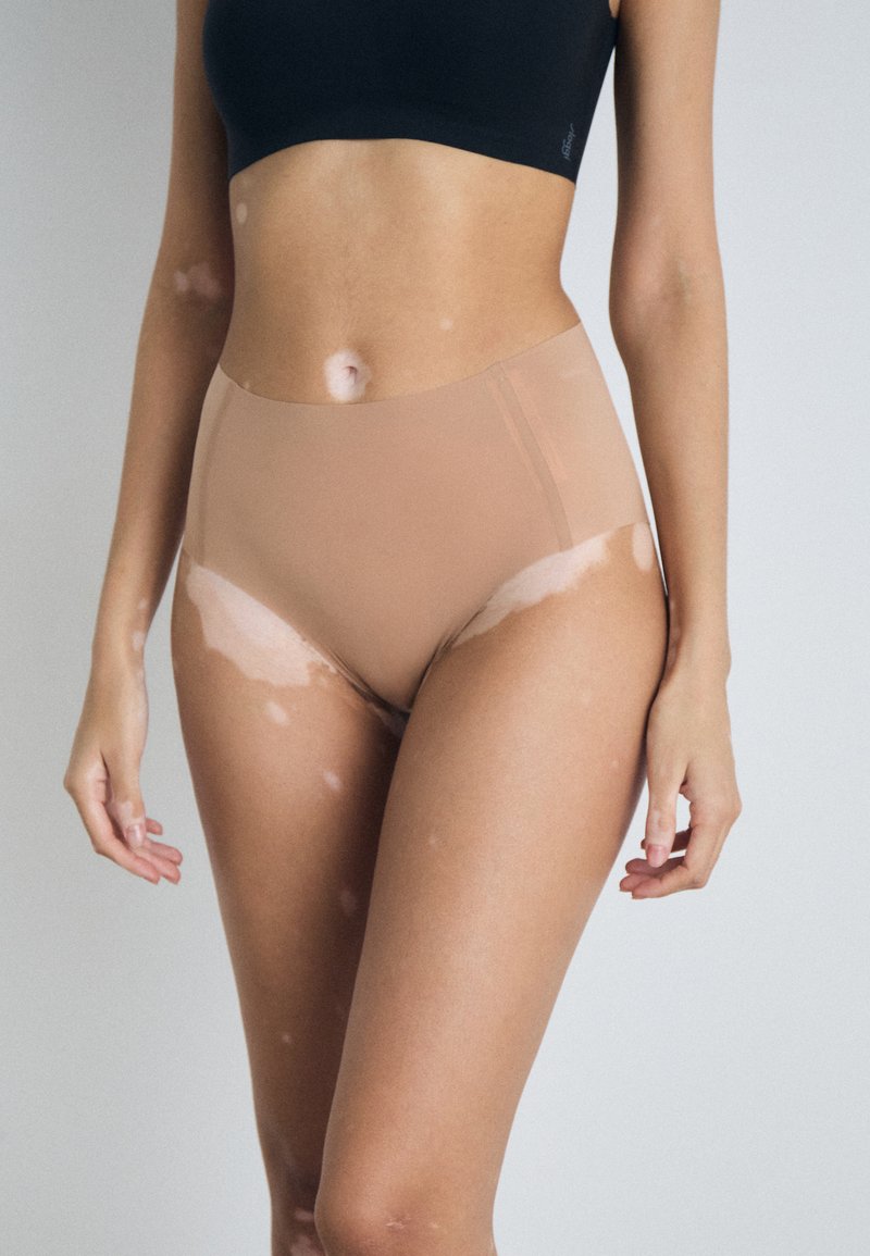 Beige hochtaillierte Unterwäsche aus glattem, dehnbarem Stoff. Verfügt über nahtlose Kanten und einen moderaten Schnitt für Komfort und Abdeckung.