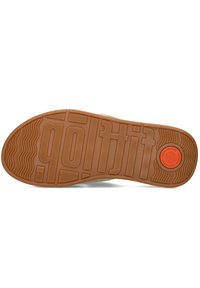 Bruine rubberen zool met een gestructureerd oppervlak, featuring een "golf"-afdruk en een ronde accent in oranje. Gladde afwerking met gedetailleerde patronen.