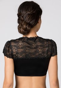 Schwarzes Cropped-Top mit transparenten Spitzenschultern, das ein florales Muster und gewellte Kanten aufweist. Der Körper ist glatt und enganliegend, wodurch eine schlanke Silhouette entsteht.
