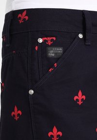 Námorně modré denimové šortky s červeným vzorem fleur-de-lis, s zipem, předními kapsami a štítkem s logem "G-Star RAW".