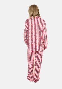 Rot-weiß gestreiftes Schlafanzug-Set mit festlichen Mustern, einschließlich Schneemännern und Weihnachtskränzen, in lockerer Passform und mit langen Ärmeln.