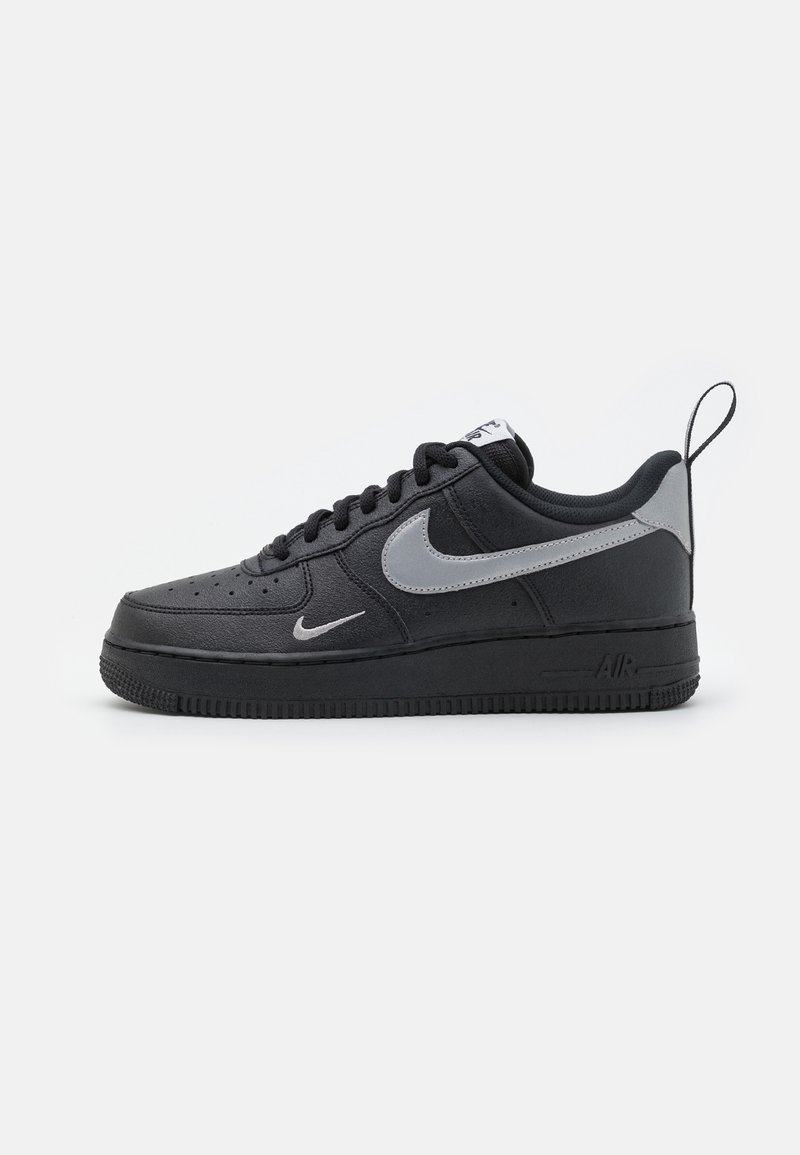 Czarne sneakersy Nike Air Force 1 z gładką skórzaną cholewką, szarym logo swoosh, sznurowanym designem i teksturowaną gumową podeszwą. Metka zawieszona z tyłu.