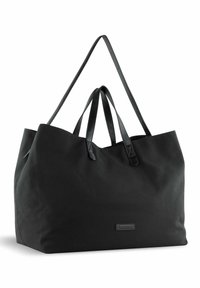 Grand sac fourre-tout noir en tissu avec des poignées en cuir. Présente une forme structurée et un logo discret à l'avant.