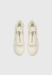 Vita högstövlar i sneakers-stil med dragkedja framtill, texturerat canvasmaterial och rund tå. Har silverfärgade detaljer och snörning på sidorna.