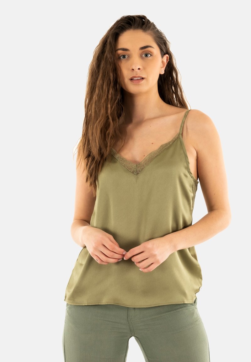 Top de satén verde oliva con tirantes ajustables y encaje en el escote en V, combinado con pantalones verdes a juego.