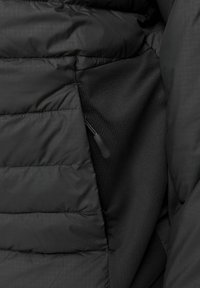 Black puffer jacket with quilted texture. Features a side pocket with a zip closure. Smooth inner lining for comfort. Matte finish.