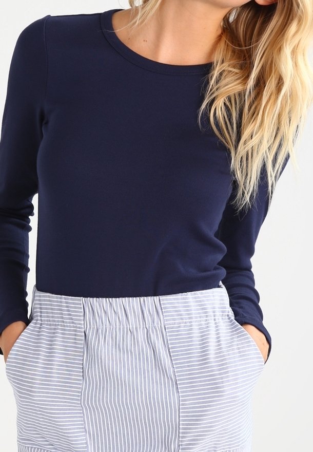 Haut à manches longues bleu marine en tissu doux, associé à une jupe rayée taille haute, dotée d'une taille élastique et de poches.