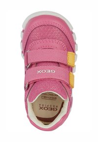 Baskets roses avec tige en maille, doubles straps Velcro, accent jaune et semelle en caoutchouc blanche. Logo sur la sangle et surface texturée.