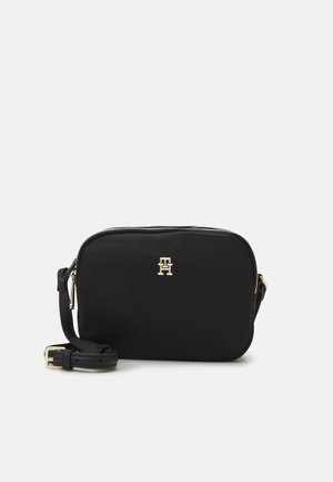 Zwarte rechthoekige crossbodytas met gouden rits, verstelbare band en klein gouden "TH"-logo aan de voorkant in het midden.