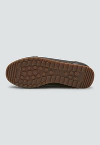 Suela de zapato con banda de goma marrón que presenta agarres circulares y un patrón rectangular, nombre de la marca "Patrick" grabado cerca del arco.