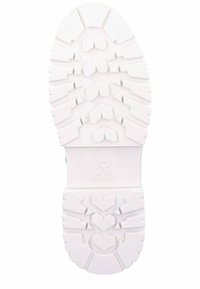 Suela de zapato de goma blanca con un diseño de tracción. Presenta surcos en espiga, texturas circulares y el detalle de marca "R EVOLUTION".