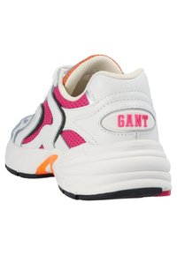 White sneaker with pink mesh accents, gray detailing, and orange highlights. Features a rounded toe and chunky white sole. Brand logo on heel.