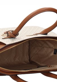 Sac fourre-tout beige avec anses en cuir marron, présentant un motif de logo à l'extérieur, une quincaillerie ton or et un intérieur doublé avec une poche zippée.