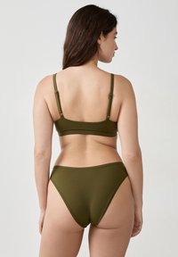 Olivgrünes Bikini-Set mit Bralette-Oberteil und verstellbaren Trägern sowie passendem hochgeschnittenen Unterteil, gefertigt aus glattem, dehnbarem Stoff.