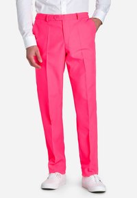 Pantaloni tailleur di un brillante colore rosa, con un design a gamba dritta, due pieghe frontali e tasche laterali, abbinati a sneakers bianche.