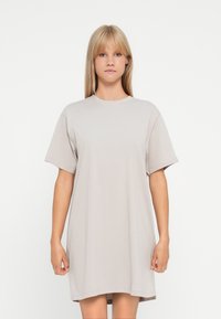 Oversized t-shirt dress in light grey cotton. Short sleeves, round neckline, and a relaxed fit with a smooth texture. No visible patterns or accents.