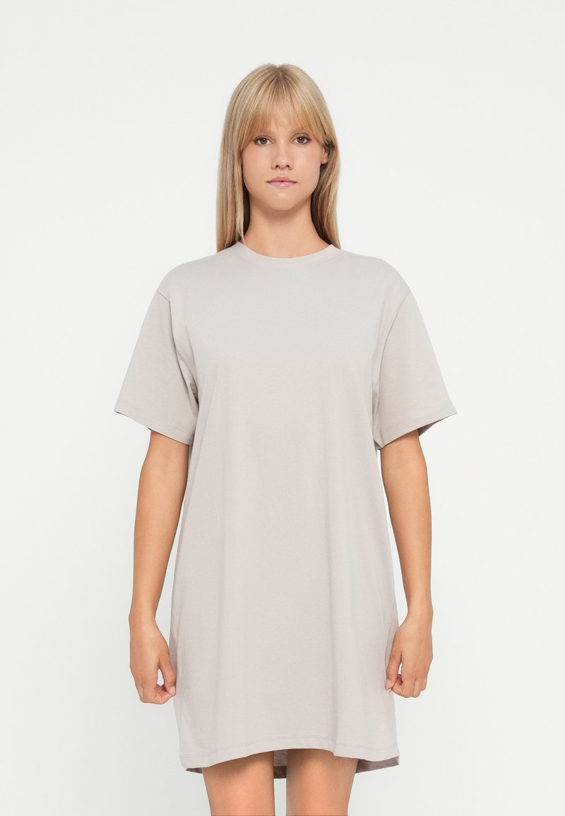 Oversized t-shirt dress in light grey cotton. Short sleeves, round neckline, and a relaxed fit with a smooth texture. No visible patterns or accents.