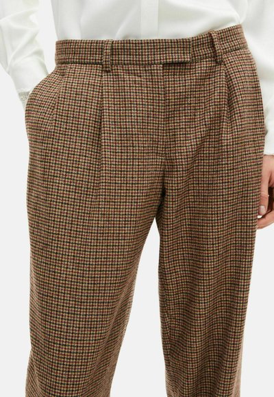 Brune og grønternede bukser med folder, der har en glat tekstur og en afslappet pasform, parret med en hvid skjorte med krave.