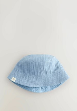 Chapeau seau bleu clair en tissu texturé, avec un large bord et une étiquette cousue sur le côté. Forme lisse et conique.