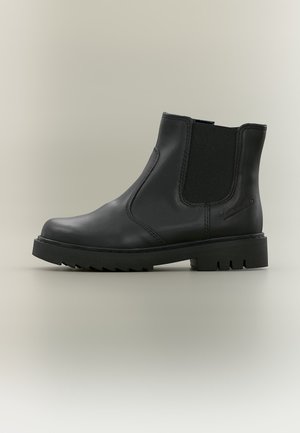 Bottine Chelsea en cuir noir avec panneaux latéraux élastiques, bout arrondi et semelle épaisse à crampons, conçue pour un usage décontracté ou formel.