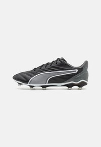 Scarpina da calcio nera con tomaia testurizzata, accenti bianchi e design elegante. Presenta un motivo lungo il lato e sei tacchetti metallici per una migliore trazione.