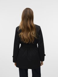 Trench-coat noir ceinturé, avec des manches longues, une silhouette structurée et des plis au dos. Finition en tissu lisse et design minimaliste.