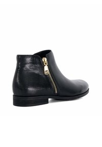 Zwarte leren enkelboots met een getextureerd zijpaneel, gouden ritssluiting en een lage gestapelde hak. Gladde afwerking aan de voorkant.