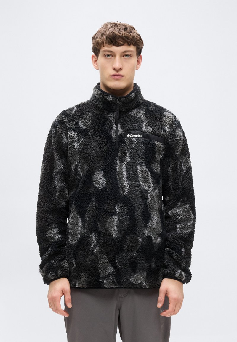 Μαύρο και γκρι φλις πουλόβερ με ψηλό γιακά, φερμουάρ στο μπροστινό μέρος μέχρι τη μέση και υφή βελούδου με διακριτικό μοτίβο. Λογότυπο στην τσέπη στο στήθος.