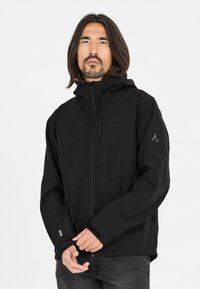 Sort softshell jakke med hætte, lynlåslommer, justerbare manchetter og en glat, struktureret overflade. Har logo på ærmet.